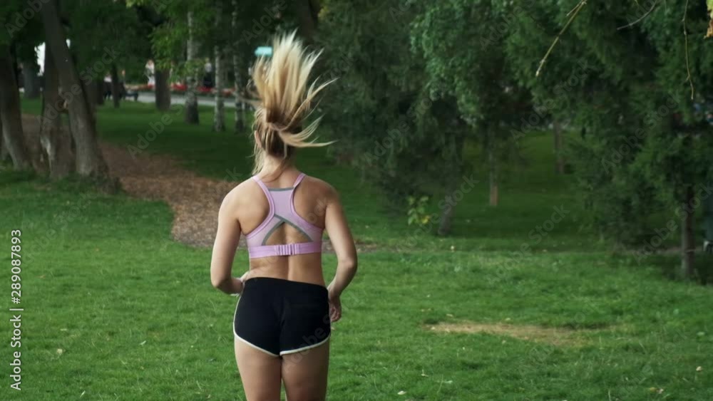 Young girl goes in for sports in nature. jogging outdoors, cardio training in the park Young girl goes in for sports in nature. jogging outdoors, cardio training in the park