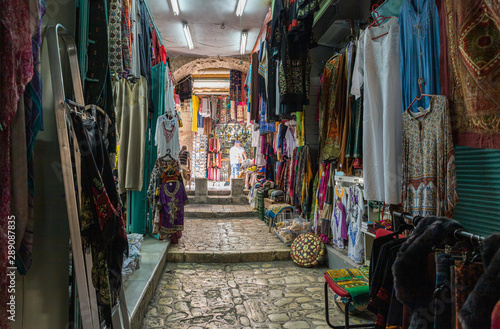 Arab bazaar with clothes located on a quiet street of the Old City in Jerusalem, Israel © svarshik