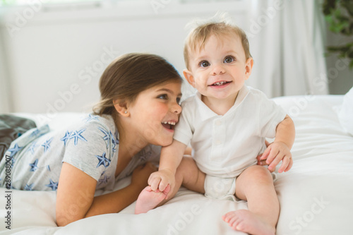 child Girl and brother Boyhaving great time on bedroom