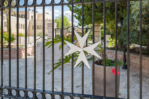 Cross of the Order of the Hospitallers on the fence of the Memorial Monument for Hospitaller hospital in the Old City in Jerusalem  Israel