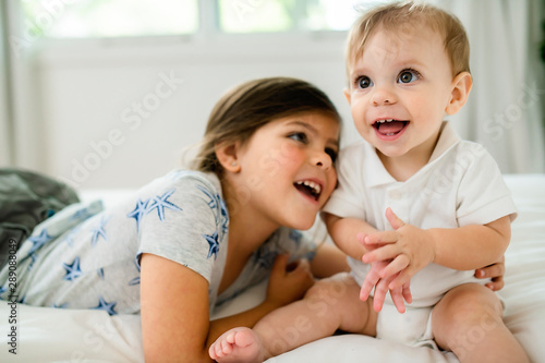 child Girl and brother Boyhaving great time on bedroom