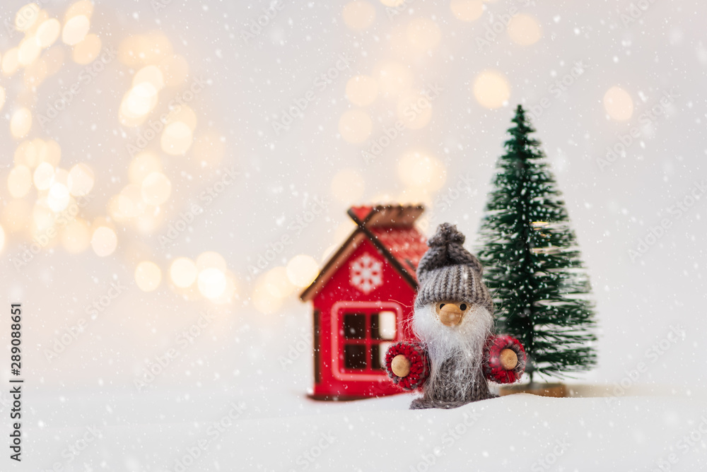 Christmas background with fir tree, house and toy man against defocused lights. Christmas or New Year celebration concept. Copy space