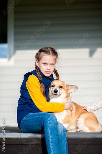 Bild auf Leinwand Girl sitting with a Corgi dog