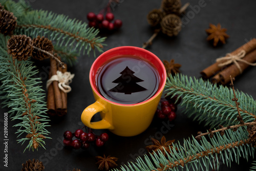Christmas mulled wine or tea with fir tree reflection on dark background. Christmas or New Year celebration concept. Copy space
