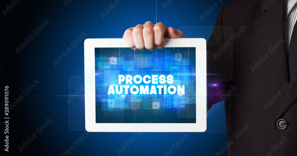 Young business person working on tablet and shows the inscription: PROCESS AUTOMATION Young business person working on tablet and shows the inscription: PROCESS AUTOMATION