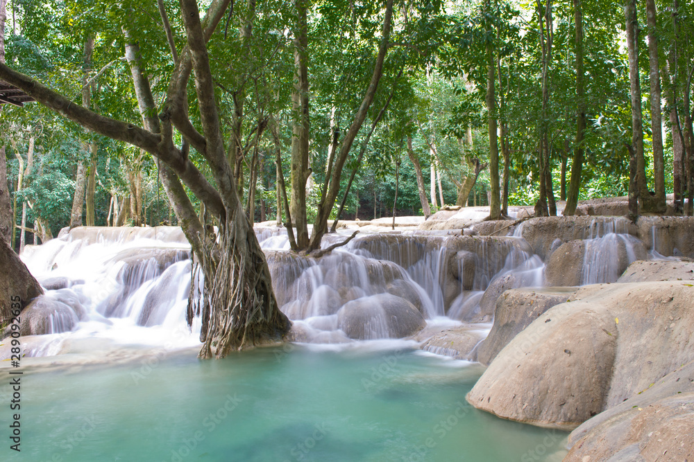 Naklejka premium Laos Tad Sae Waterfall in the green forest, long exposure showing the nature of Laos, displaying soft water and tropical paradise, vivid colors