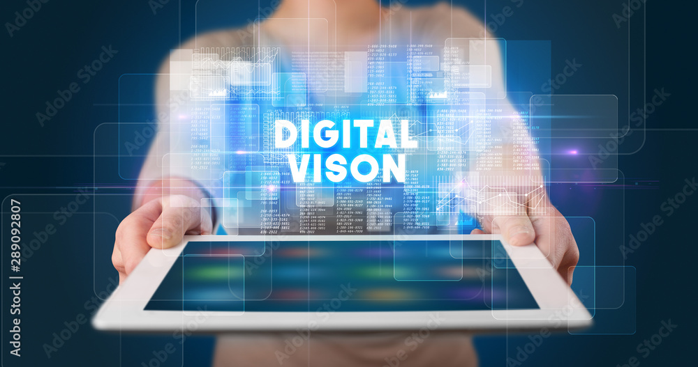 Young business person working on tablet and shows the inscription: DIGITAL VISON Young business person working on tablet and shows the inscription: DIGITAL VISON