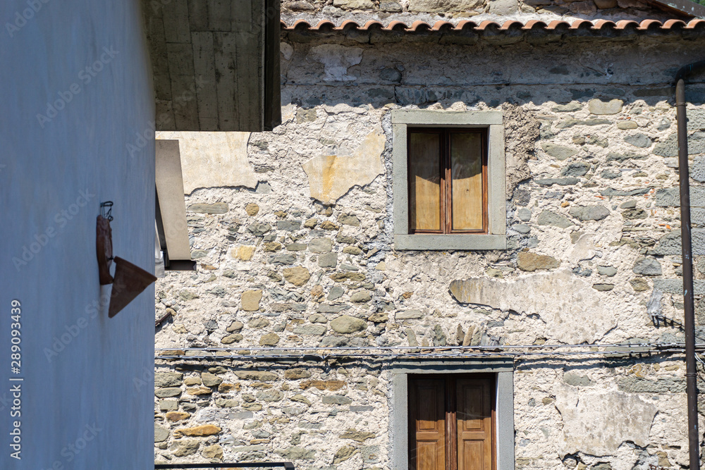 Close up old, stone house with wood door and window. Old village, Codiponte, Italy Close up old, stone house with wood door and window. Old village, Codiponte, Italy