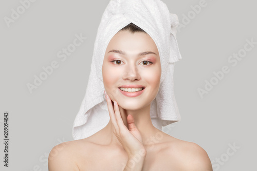 Fashion woman happiness beautiful smile. Healthy skin and a towel around the head. Gray background