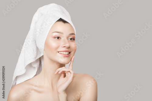 Fashion woman happiness beautiful smile. Healthy skin and a towel around the head. Gray background