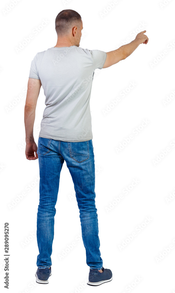 Back view of a man in jeans points his hand upwards. Back view of a man in jeans points his hand upwards.