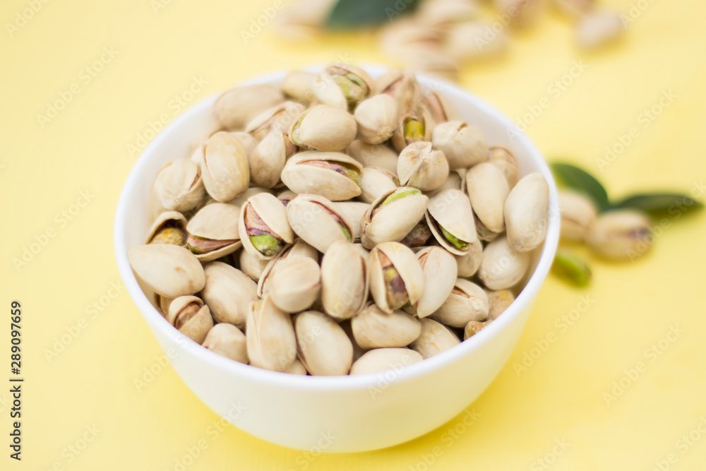Nuts, pistachios from above on yellow background Nuts, pistachios from above on yellow background