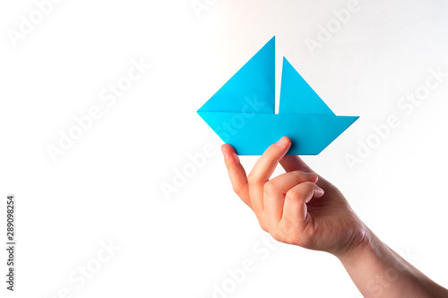 Paper ship in the hand. Blu...