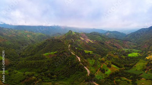 Aerial view Road on the top of a hill with lush greenery The atmosphere of the morning with fog Suitable for driving holiday travel.