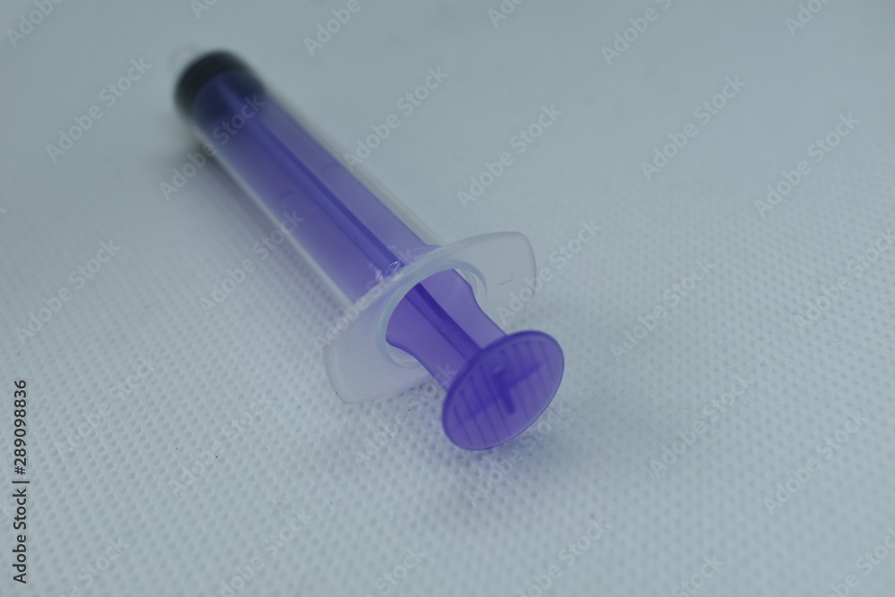 Naklejka premium A blue medical syringe as used by medical professionals.