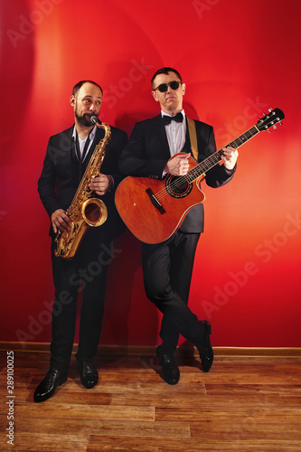 Canvas Print Group of two musicians, male jazz band, guitarist and saxophonist in classical c