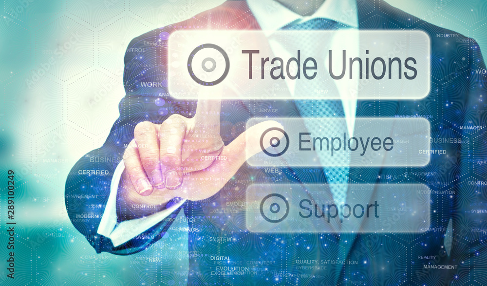 A businessman selecting a Trade Unions button on a futuristic display with a concept written on it.