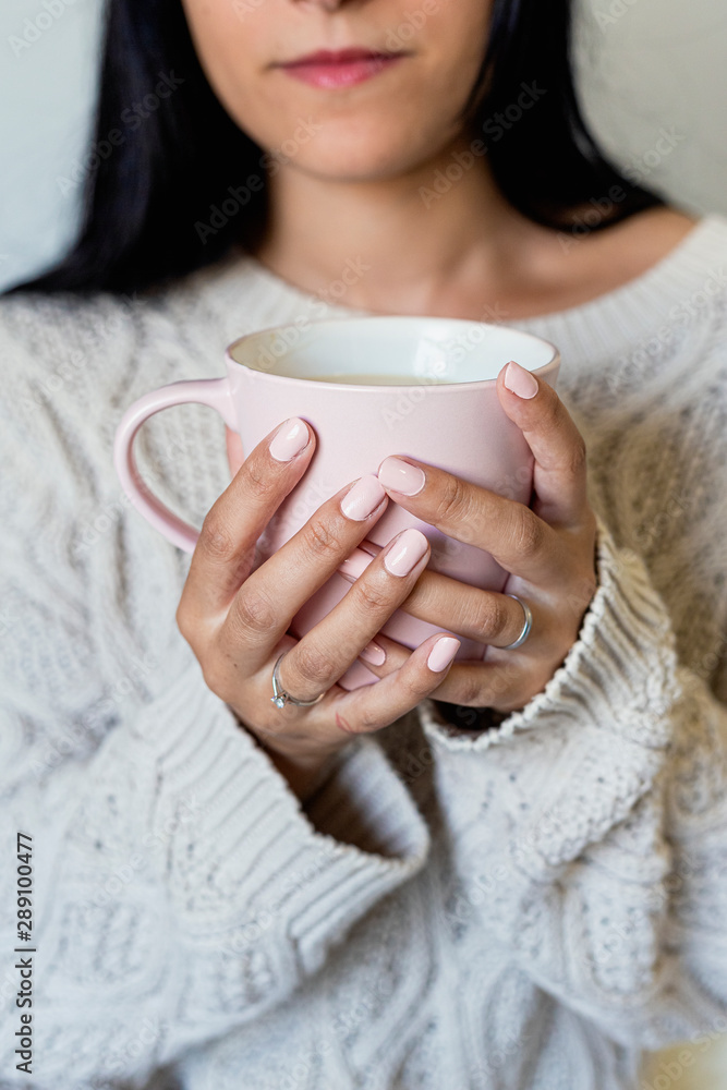 Portrait of a beautiful young woman holding a cup of hot coffee Portrait of a beautiful young woman holding a cup of hot coffee