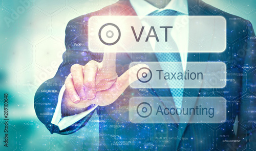 A businessman selecting a VAT button on a futuristic display with a concept written on it.