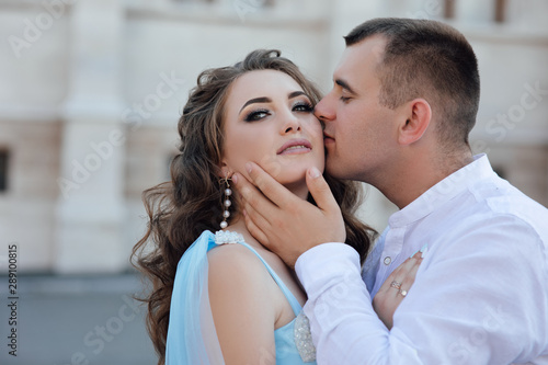 A guy in love walks with his girlfriend. Gorgeous couple man and tende woman hug each other. Attractive young stylish couple in love outdoors. Love story in in Prague. 