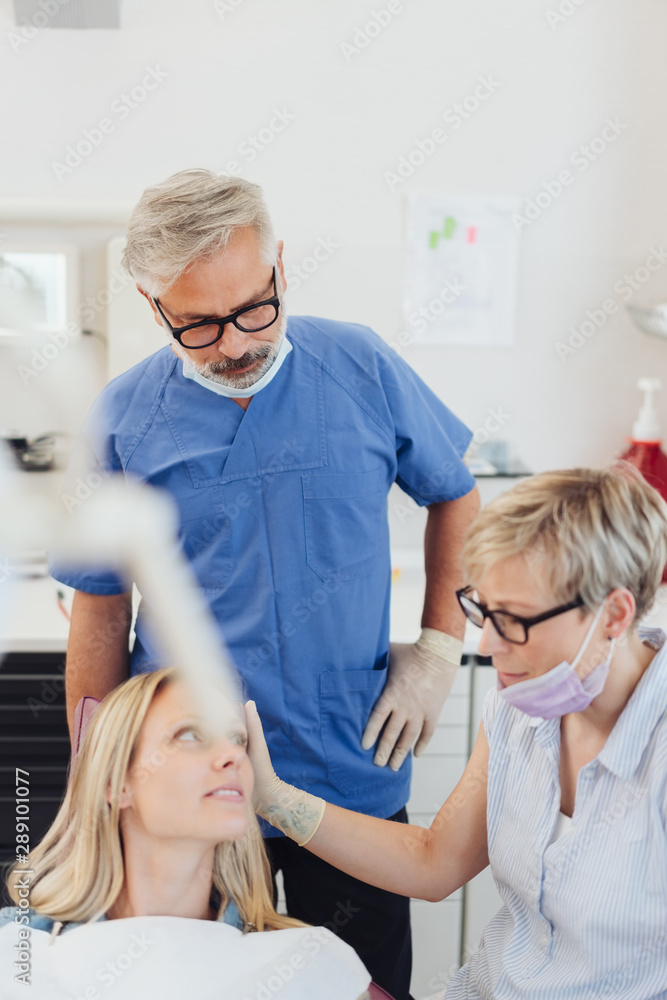 Dentist comforting a female patient in the surgery Dentist comforting a female patient in the surgery