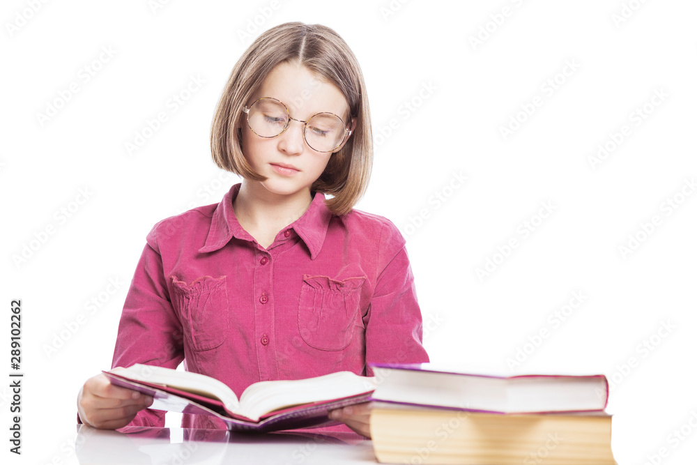 Tired girl teenager in glasses sits at a table with books. Isolated over white background. Tired girl teenager in glasses sits at a table with books. Isolated over white background.
