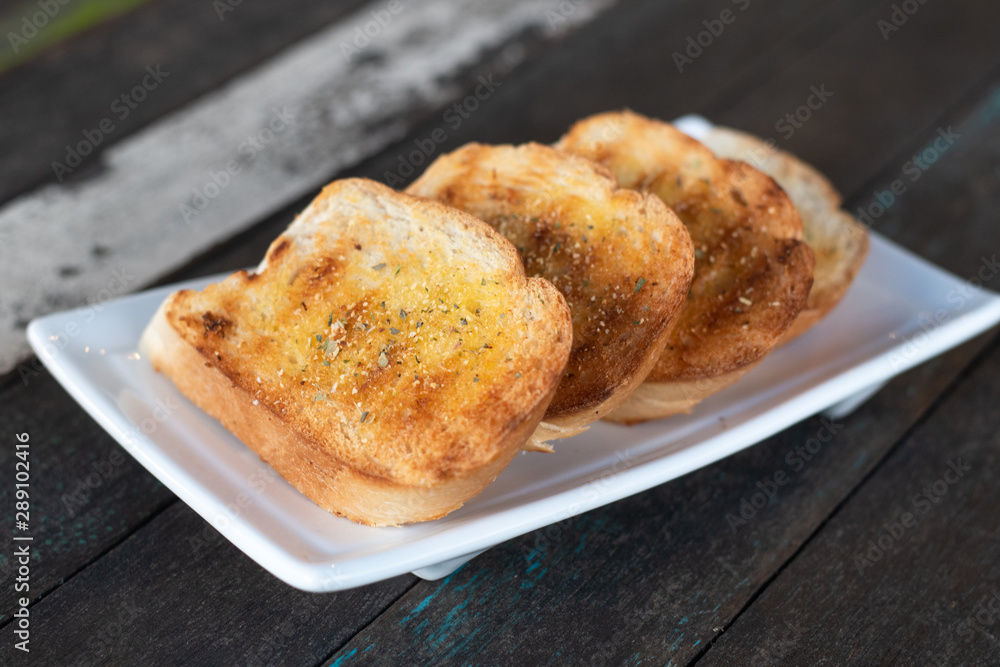garlic bread. Tasty bread with garlic, cheese and herbs on kitchen table