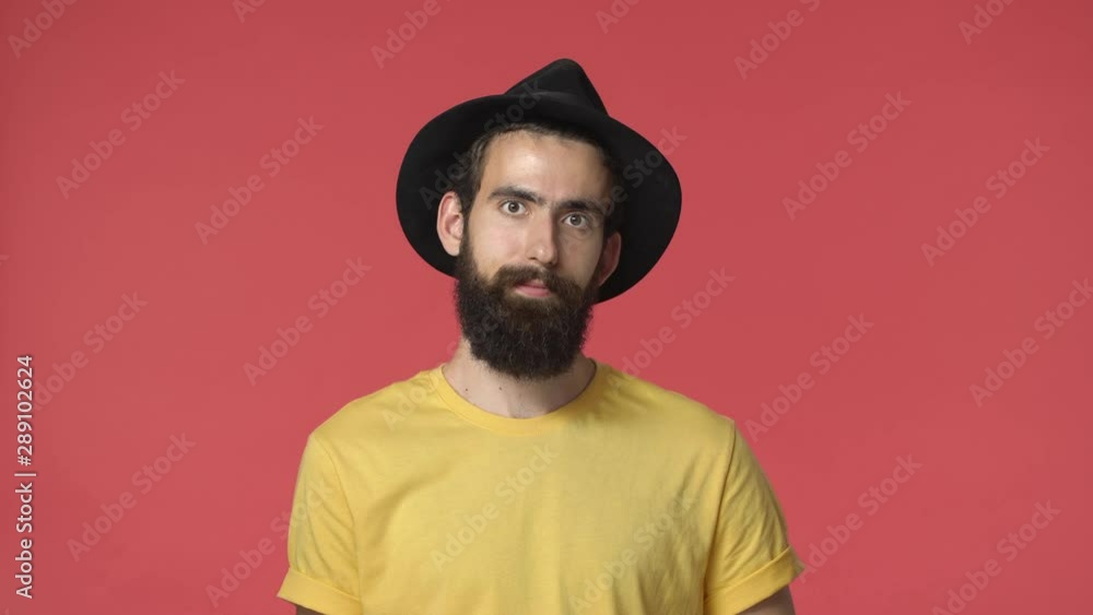 Handsome middle-eastern bearded jewish guy in black hat, yellow t-shirt, passionately talking, explaining something, gesturing and nod acceptingly, say yes, approve friend opinion, red background Handsome middle-eastern bearded jewish guy in black hat, yellow t-shirt, passionately talking, explaining something, gesturing and nod acceptingly, say yes, approve friend opinion, red background
