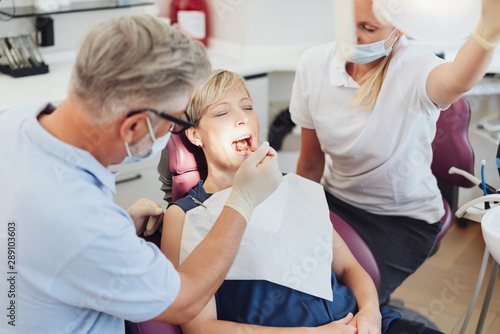 Dentists examining a woman patients teeth