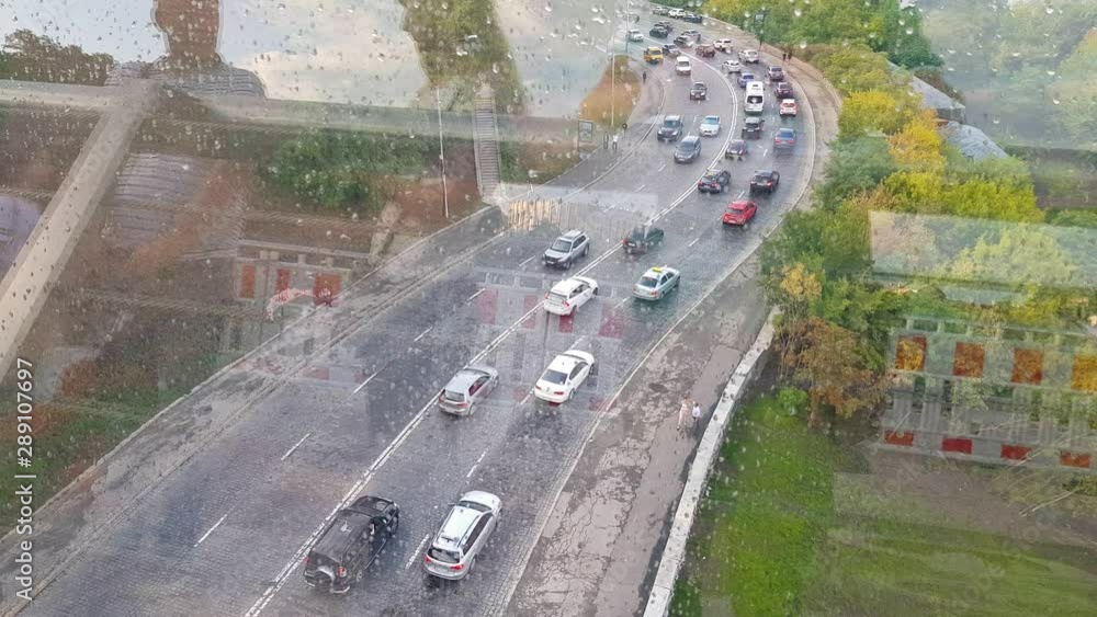 road with cars through the glass with raindrops. view from above road with cars through the glass with raindrops. view from above