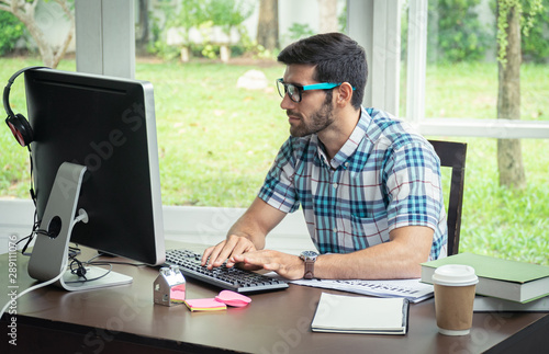 Good looking young business man working on the internet at home