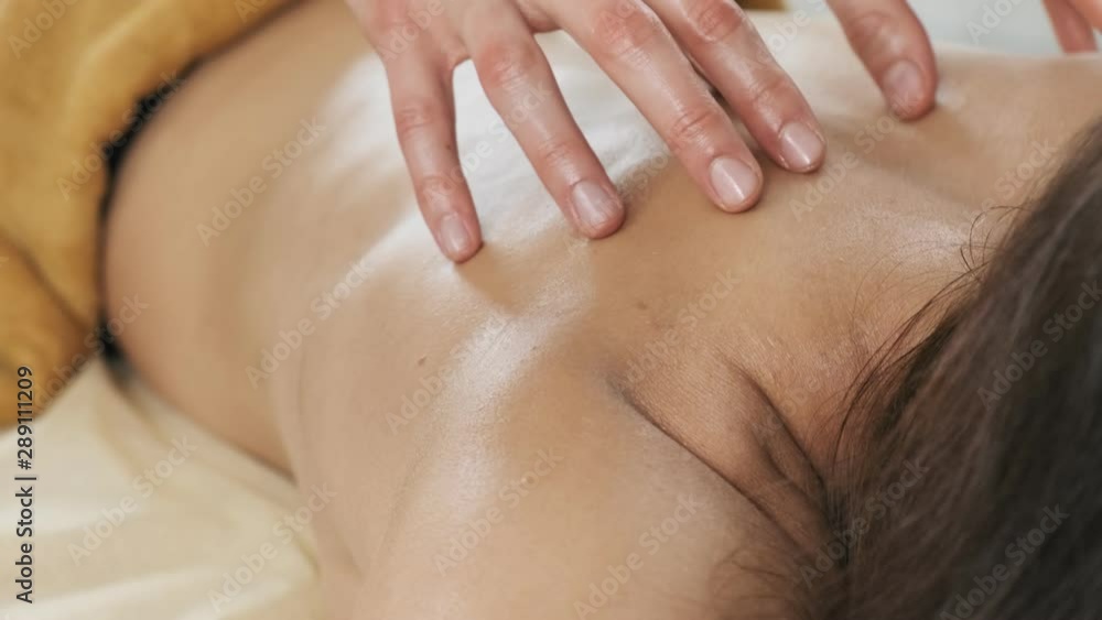 Body relaxation and skin care. Close-up of woman enjoying back massage at spa club. Female relaxing lying on massage table Body relaxation and skin care. Close-up of woman enjoying back massage at spa club. Female relaxing lying on massage table