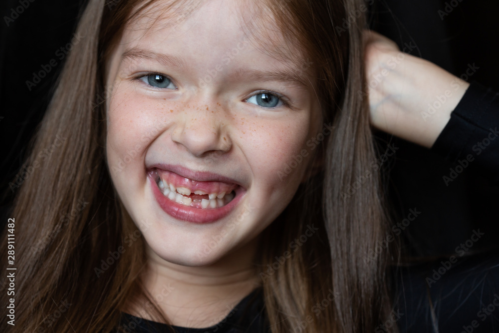 Portrait of a little beautiful smiling laughing girl with long hair. Lost milk tooth. Portrait of a little beautiful smiling laughing girl with long hair. Lost milk tooth.
