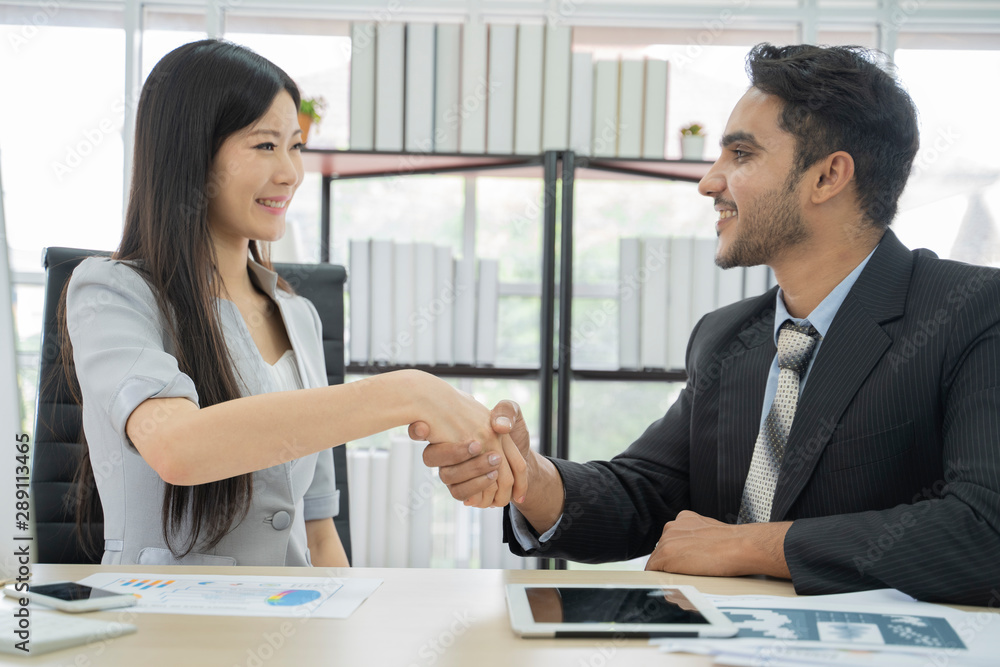 Business men shaking hands with asian business woman, after finishing up a meeting. Business men shaking hands with asian business woman, after finishing up a meeting.