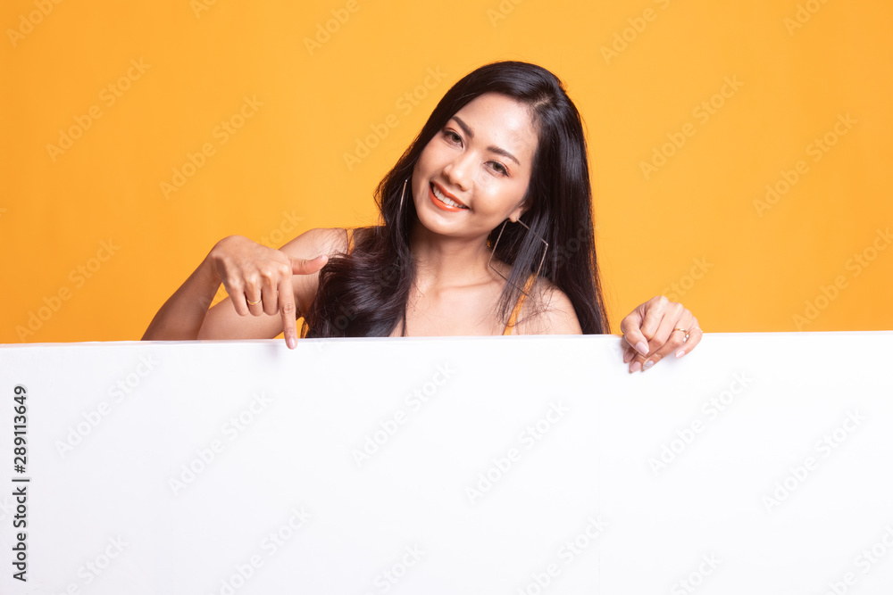 Young Asian woman point to a  blank sign.