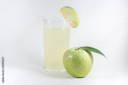 glass of juice and green apple on white background