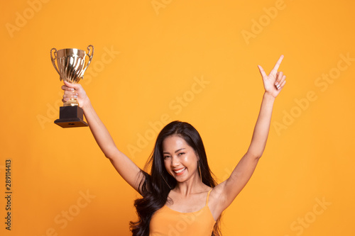 Successful number one winner young asian woman holding a trophy.