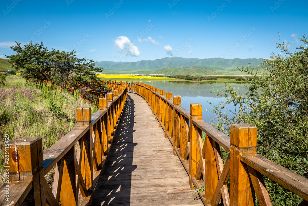 Obraz premium Wooden pathway at Sangke wetlands and grasslands, Xiahe, Gannan, China. 