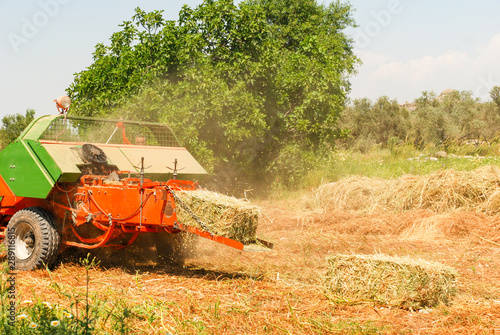 Machine for harvesting form square bales of hay.