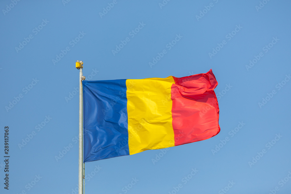 Romania flag waving against clean blue sky, close up Romania flag waving against clean blue sky, close up