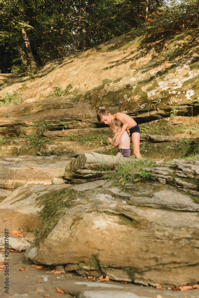 Brother with his little sister bathe in the mountain river. Brother with his little sister bathe in the mountain river.