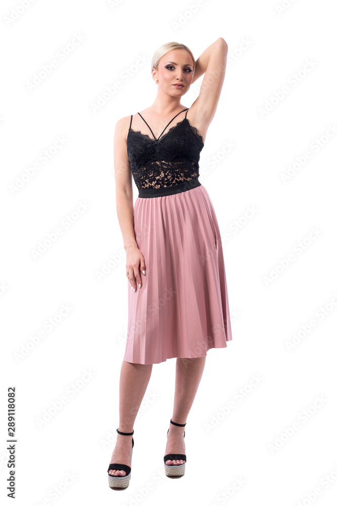 Sexy confident blonde woman in black lace top and pink skit posing for camera. Full body isolated on white background. Sexy confident blonde woman in black lace top and pink skit posing for camera. Full body isolated on white background.