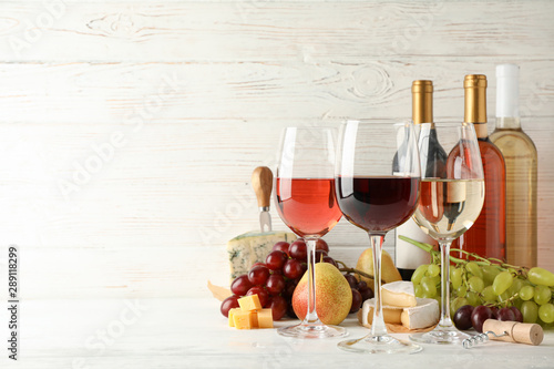 Fototapeta Naklejka Na Ścianę i Meble -  Fruits, cheese, bottles and glasses with different wine on white background, space for text