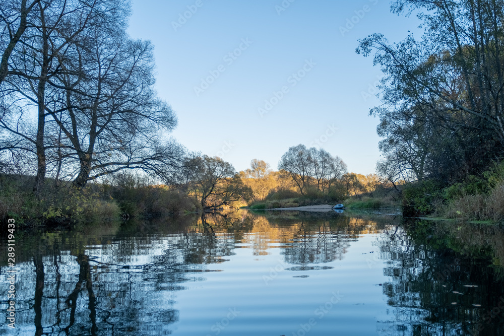 beautiful landscape of the river, blue sky with clouds, reflection of clouds and trees in water, clouds in the river, winding river, river in the field, summer, a tree near the water