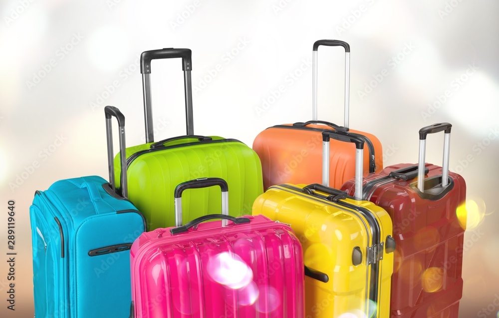 Many multi-colored big suitcases on bokeh background Many multi-colored big suitcases on bokeh background