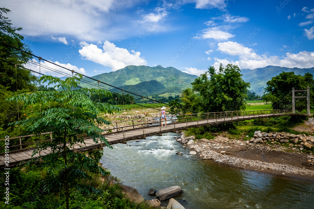 Young woman walking on a bridge in Vietnam. Hiking area at Son Luong, close to Nghia Lo, Yen Bai district, Vietnam. 