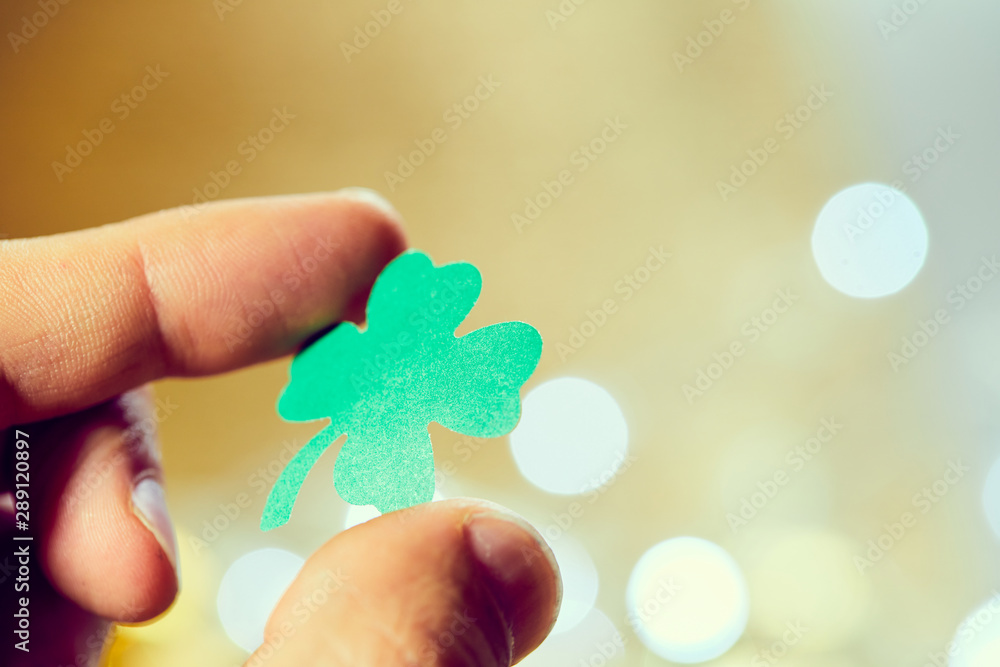 leaf of clover shape cut from paper in the hand leaf of clover shape cut from paper in the hand