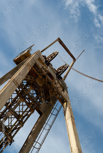 Mining old equipment. Shaft head frame in steel, detail of the wheels and cables. photo