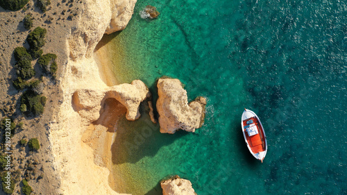 Aerial drone top down photo of traditional red wooden fishing boat in secluded paradise beach of Kasteli in Kato Koufonissi island with turquoise clear sea, Koufonissia, Small Cyclades, Greece