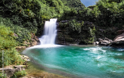 Emerald green waterfall at Du Gia  at the Ha Giang loop in Northern Vietnam. Stunning landscape long exposure photo. 